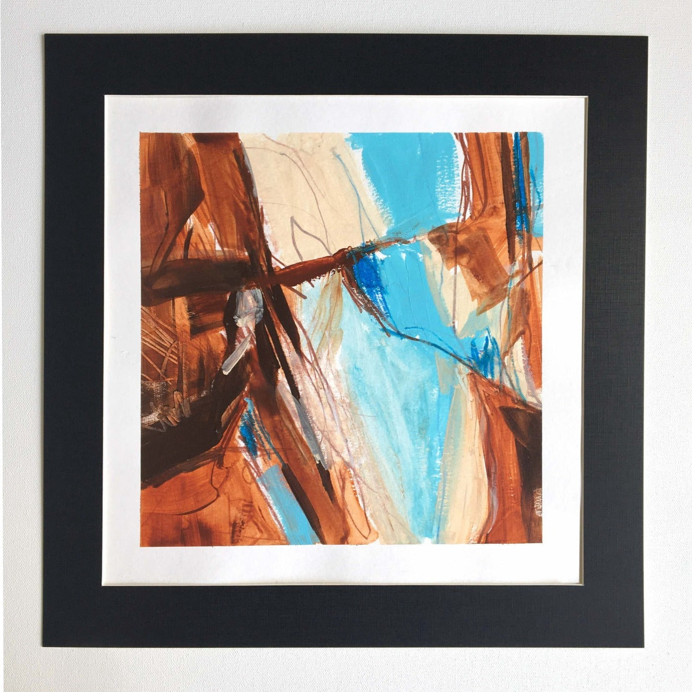 One-of-a-kind mixed media artwork in burnt umber, burnt sienna, sky blue light, white, warm gray, and black colors. Intuitive composition in the artist's art practice. Framed in black, matt paper frame.